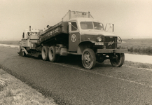 847898 Afbeelding van een asfalteermachine van de firma Strijland (Uithoorn) achter een vrachtwagen van dezelfde firma, ...